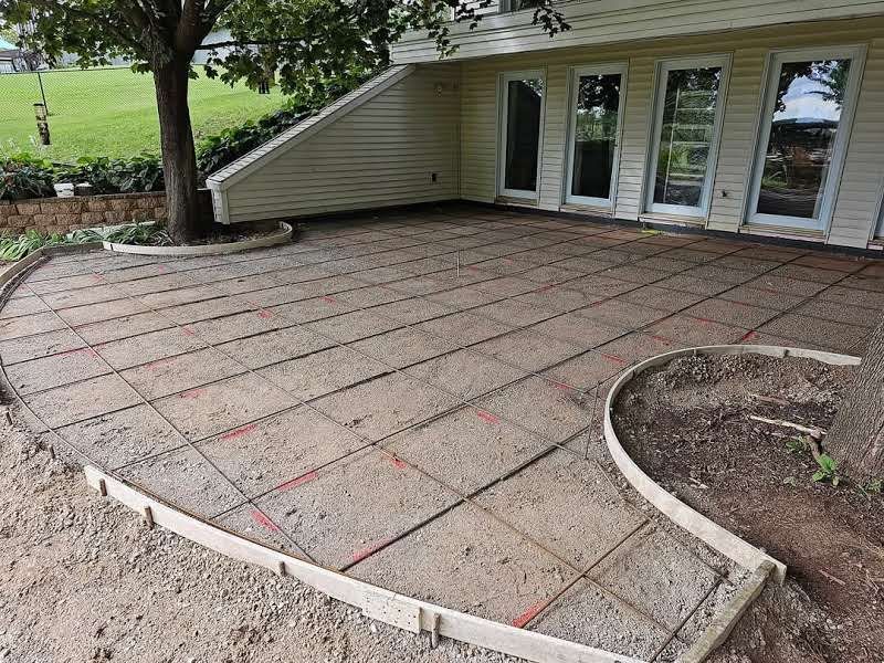 A patio is being built in front of a house.