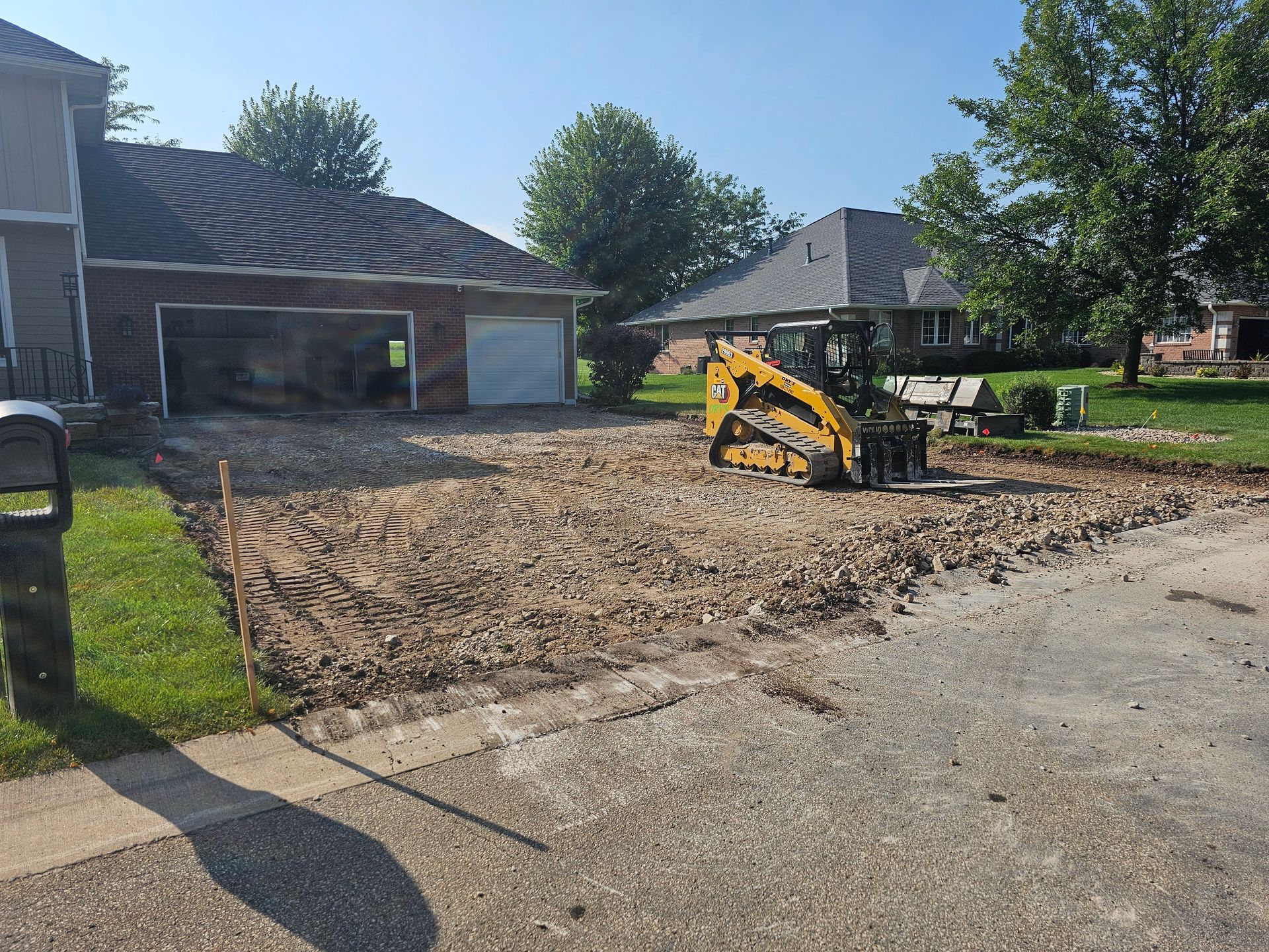 A yellow bulldozer is sitting in the dirt in front of a house.