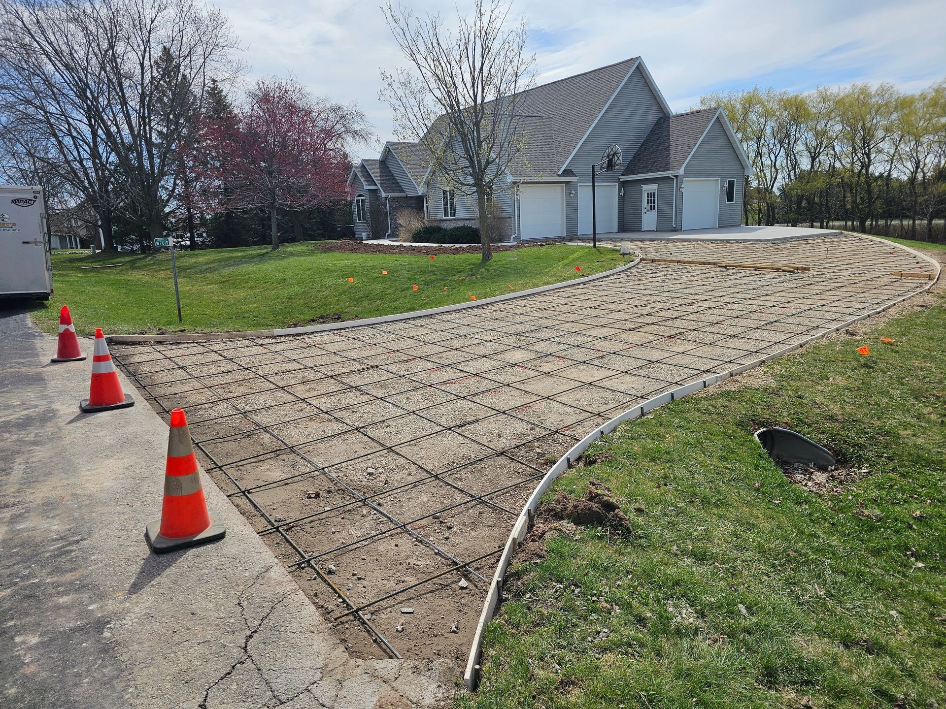 A concrete driveway is being built in front of a house.