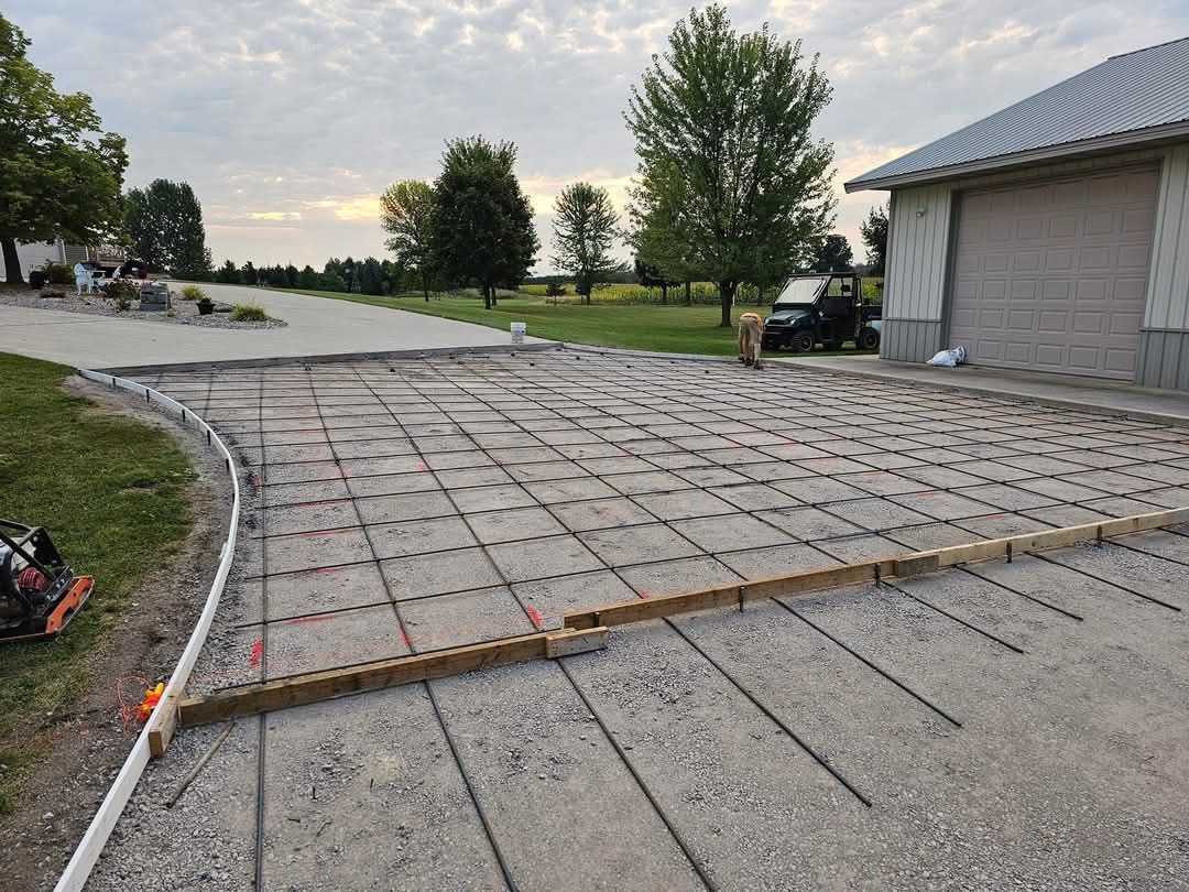 A concrete driveway is being built in front of a house.