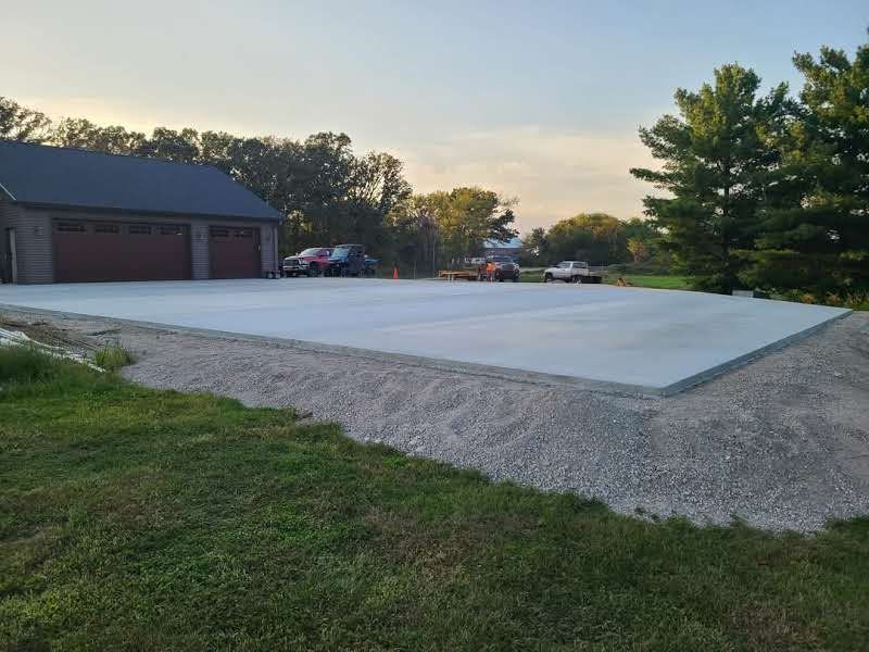 A concrete driveway is being built in front of a garage.