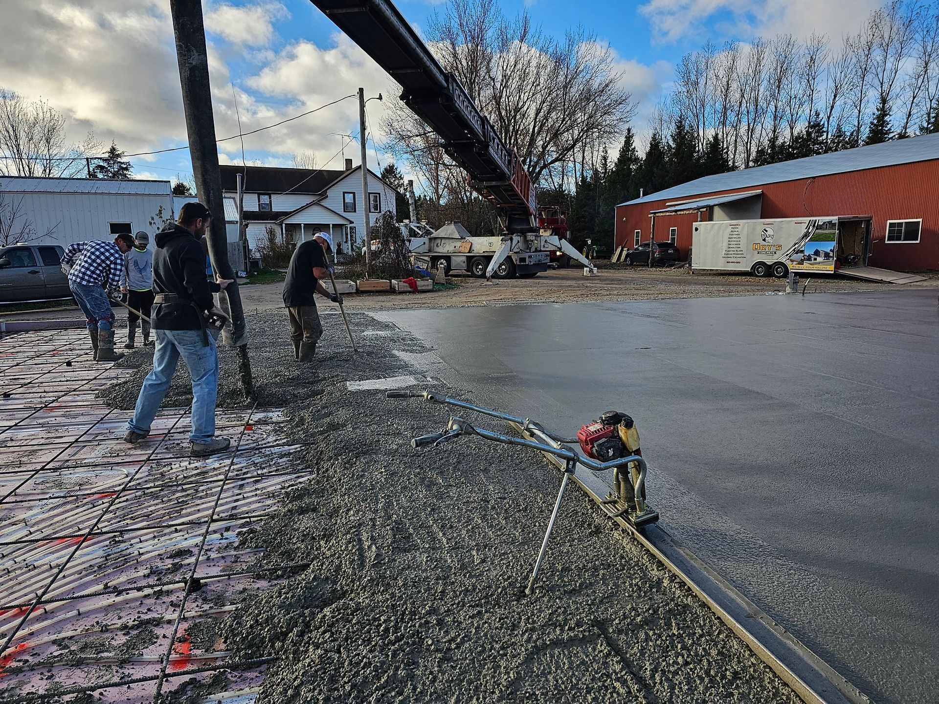 A crane is pouring concrete into a parking lot