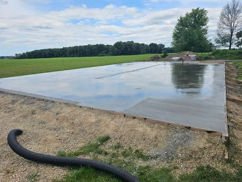 A large concrete slab is sitting in the middle of a field.