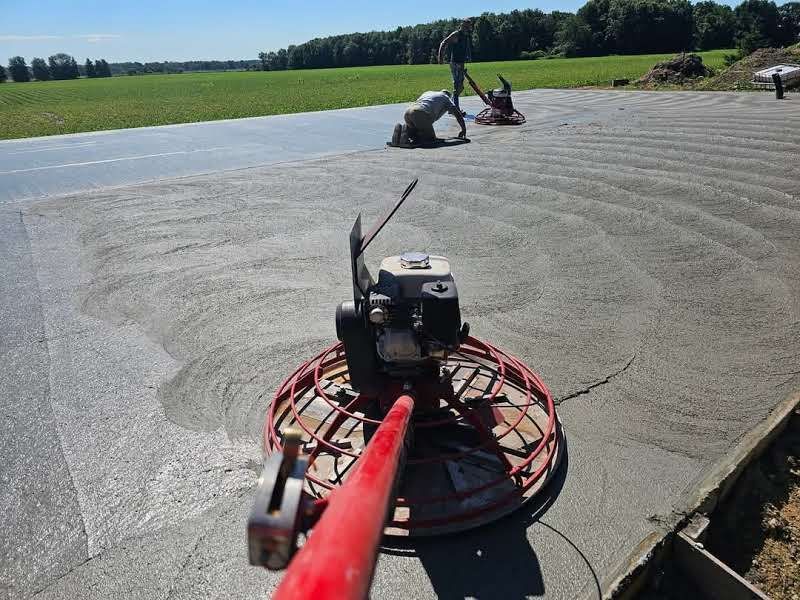 A concrete finisher is being used to finish a concrete driveway.