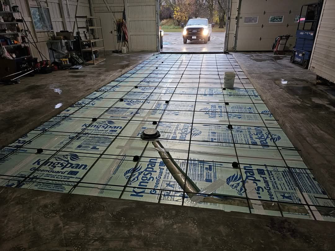 A car is driving through a garage door with a lot of insulation on the floor.