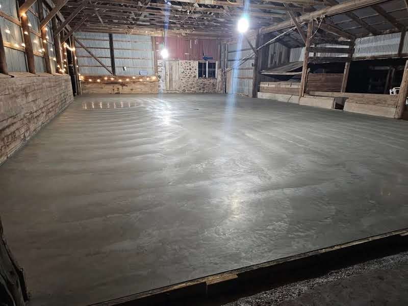 There is a concrete floor in the middle of a barn.