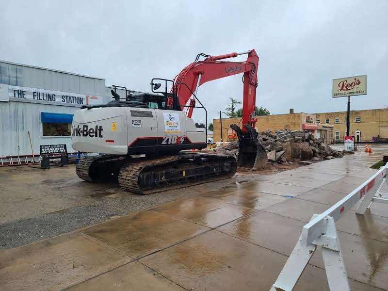 A large excavator is parked in front of a building.