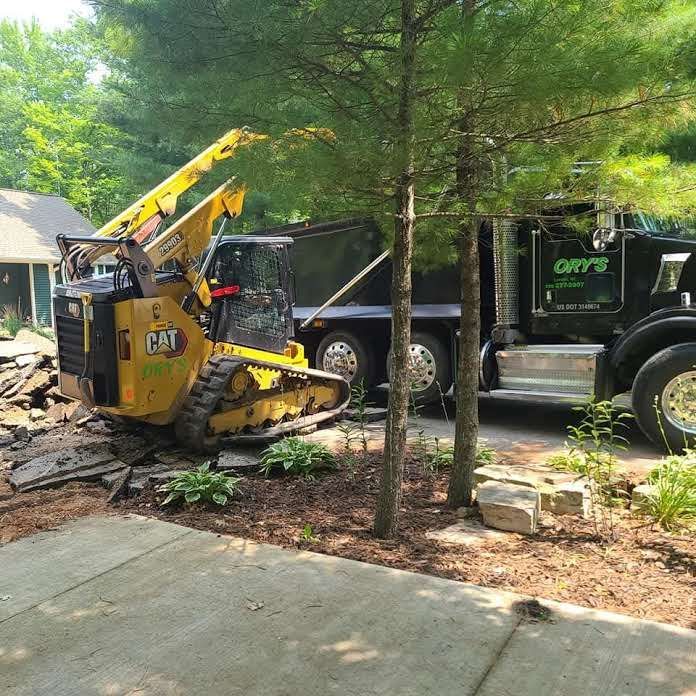 A cat bulldozer is parked next to a dump truck.