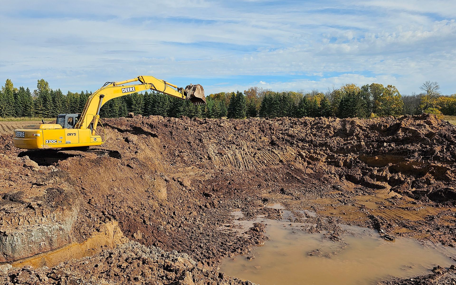 A yellow excavator is digging a hole in the dirt.