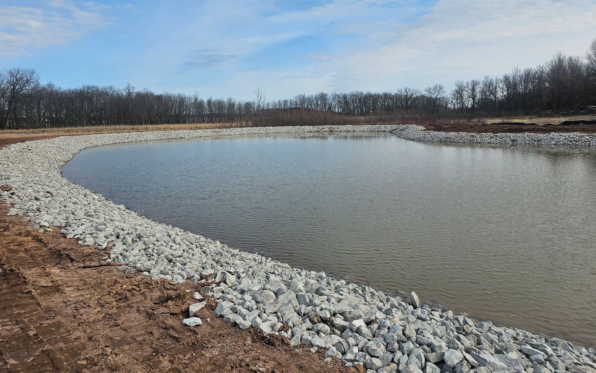 A large body of water surrounded by rocks and gravel.