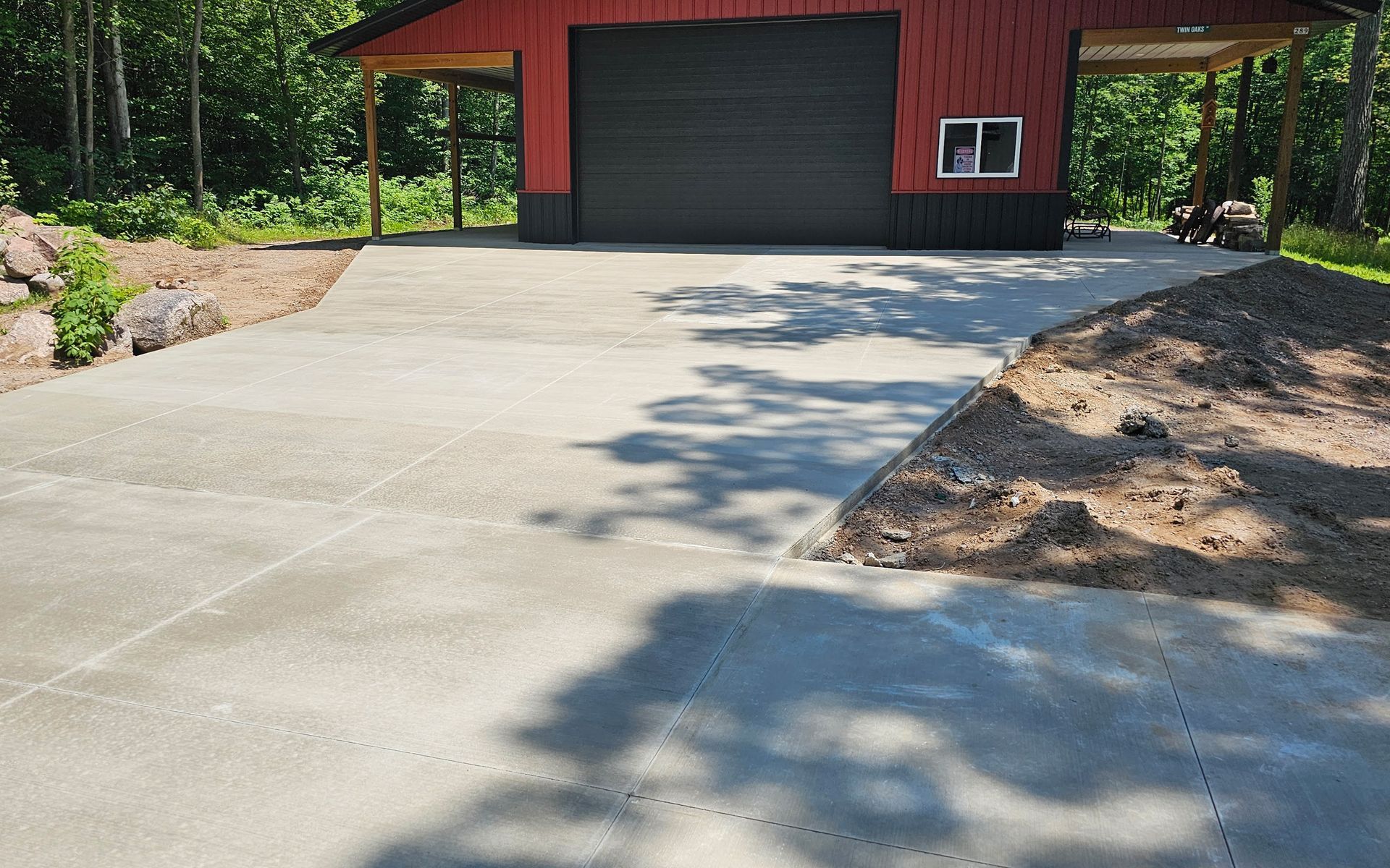 A concrete driveway leading to a red garage
