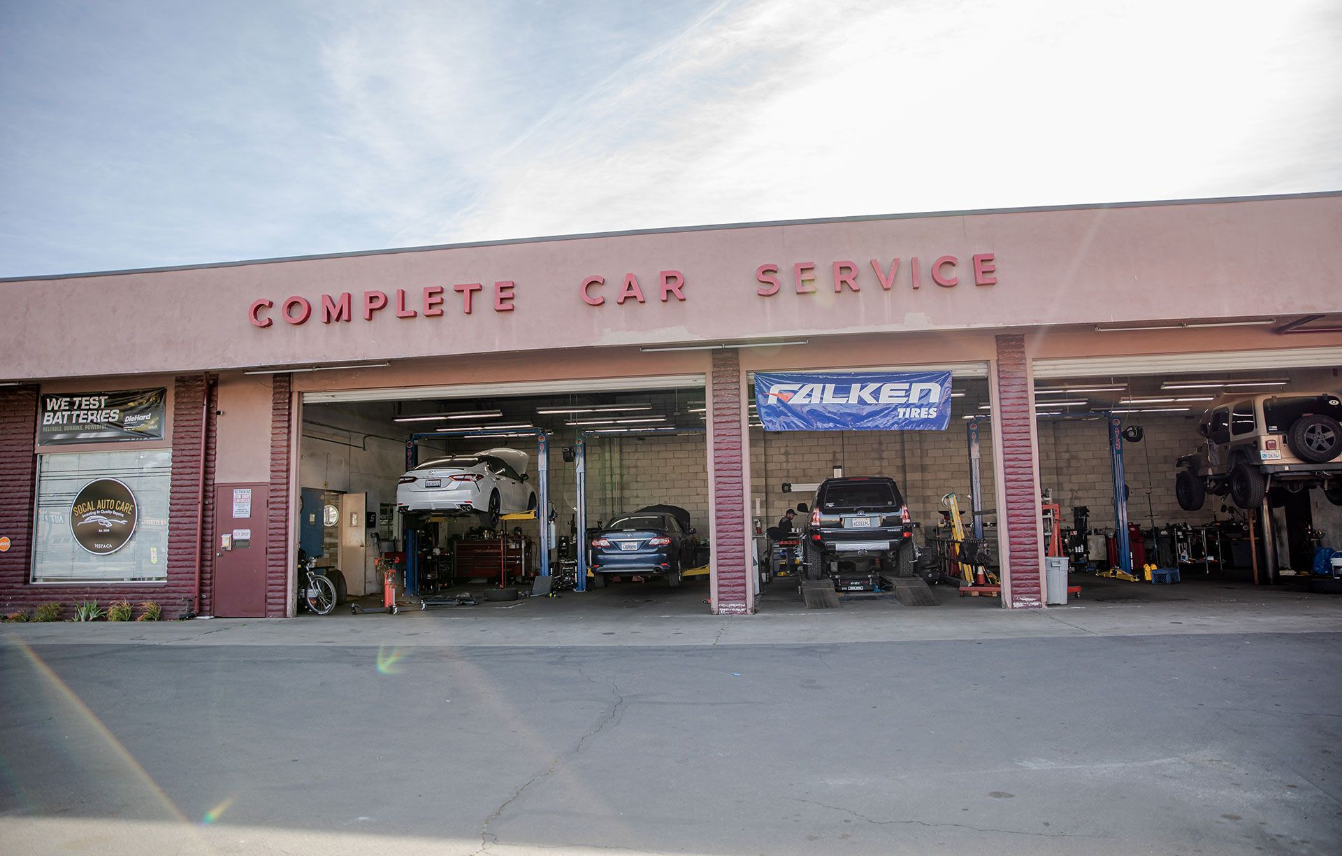 Complete Car Service auto shop with open bays and cars inside, storefront sign visible