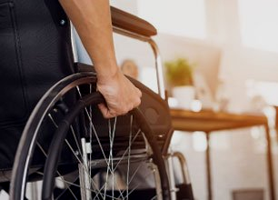 Man is sitting in a wheelchair.