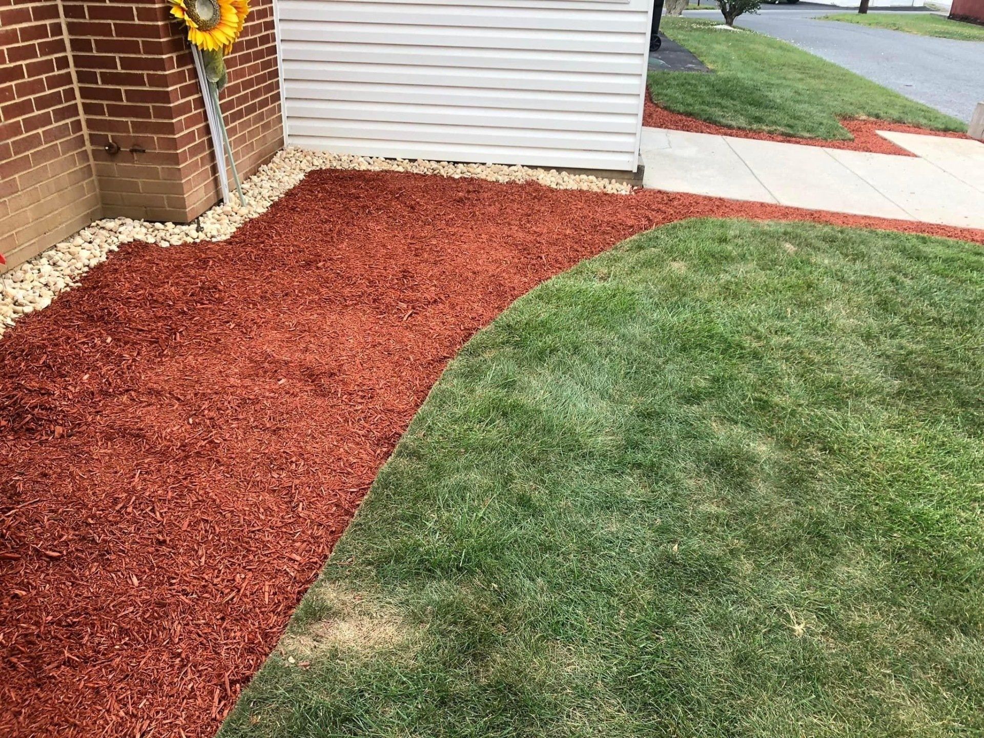 Red mulch, pebbles, and green grass