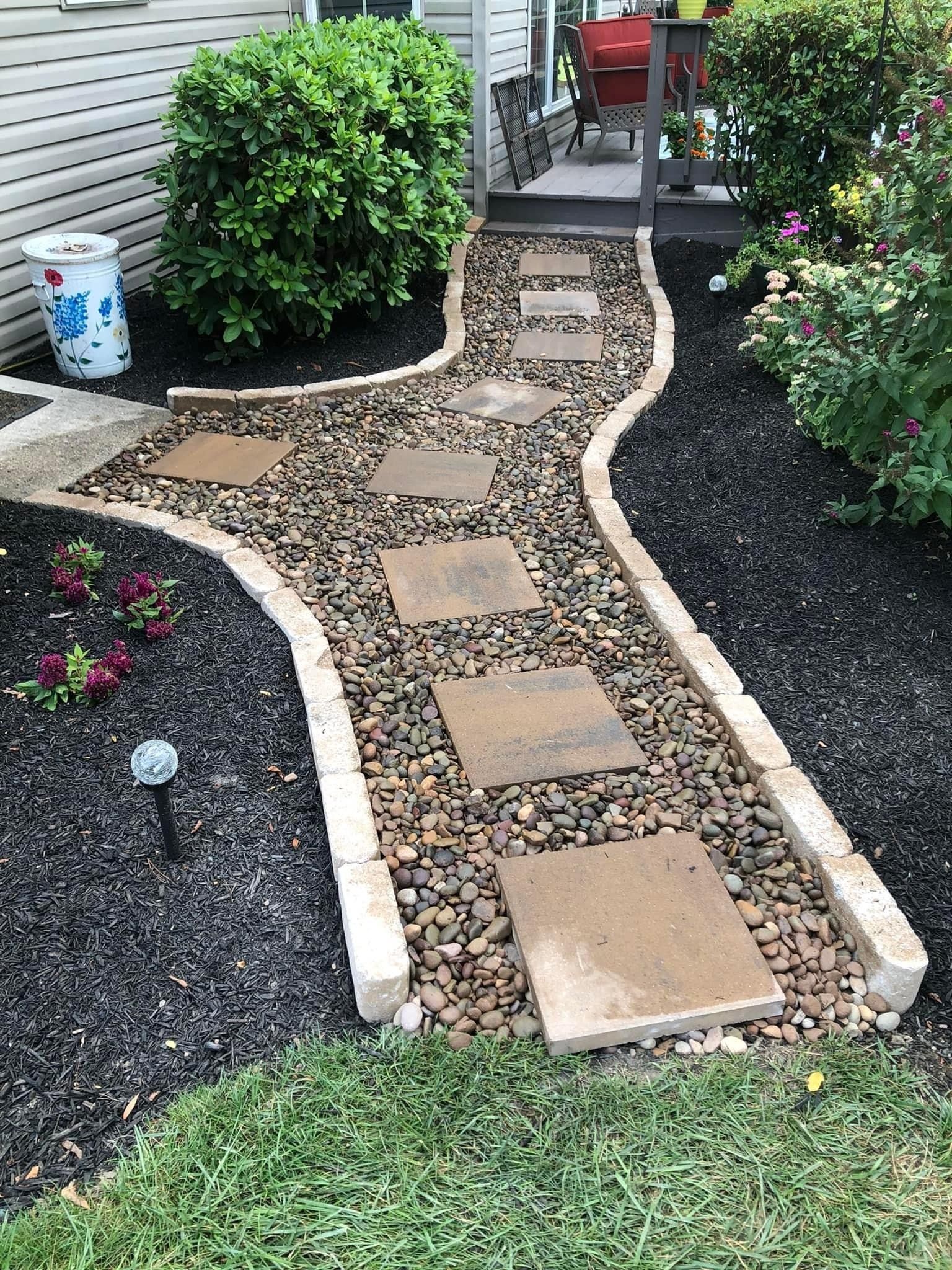 A walkway with stylish pavers and pebbles