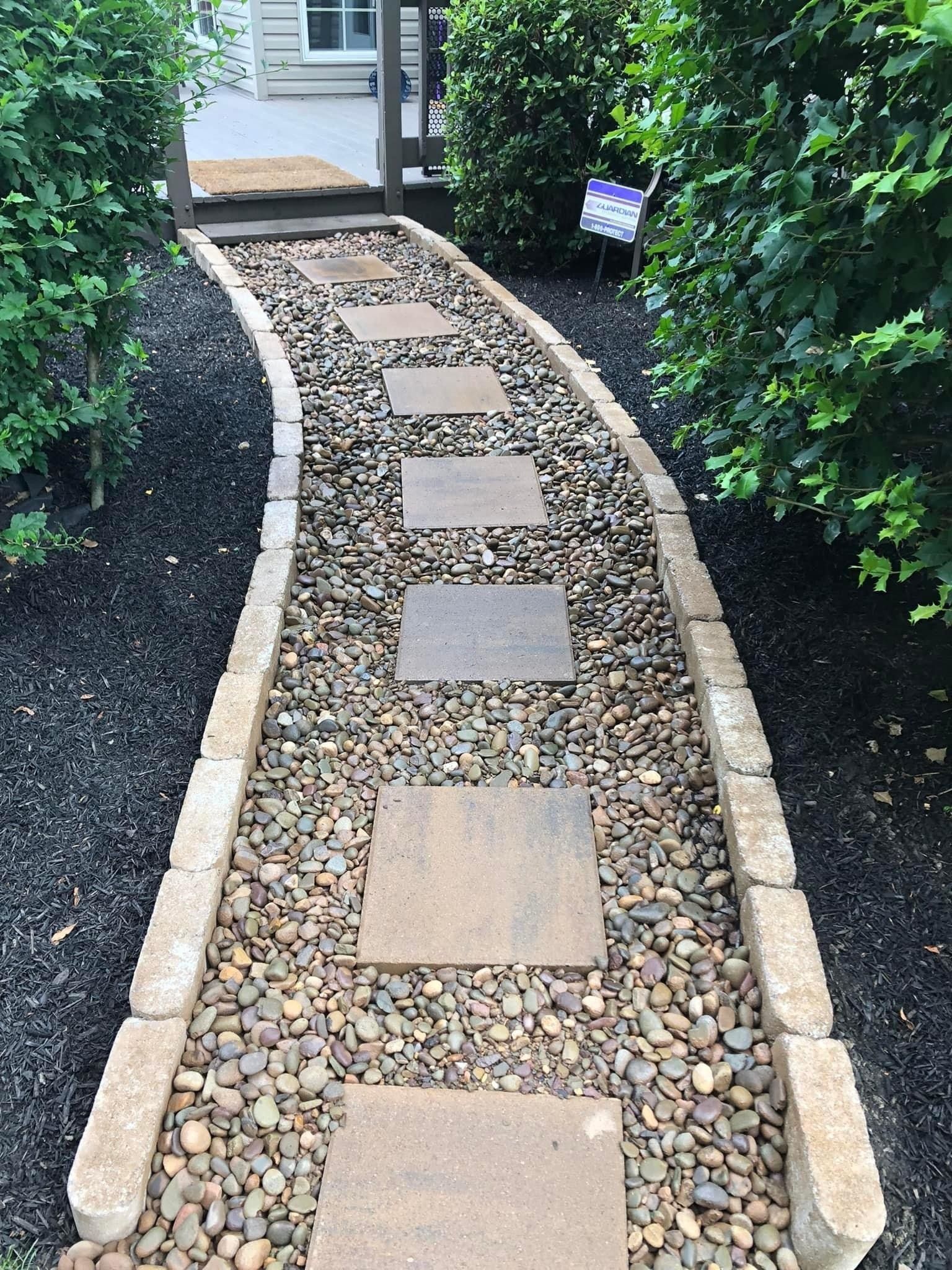 An elegant walkway with stylish pavers and pebbles