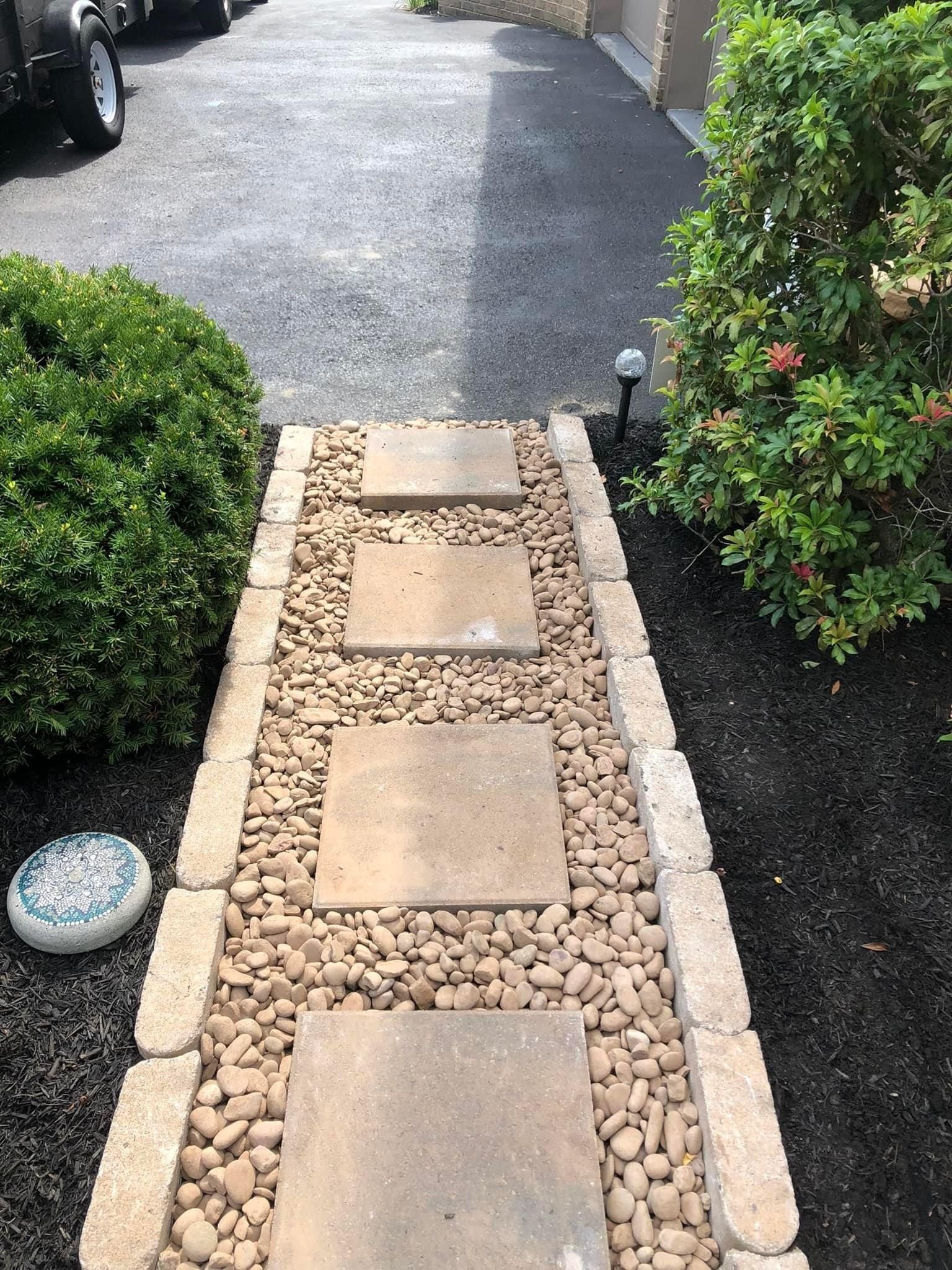 A new walkway with stylish pavers and pebbles