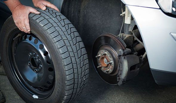 A person is changing a tire on a car.