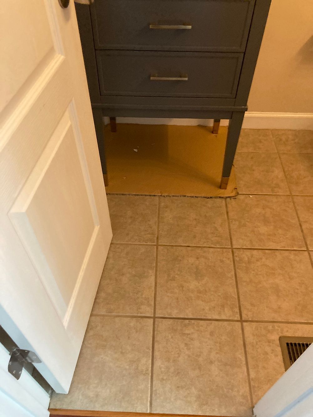 A bathroom with a dresser and a tiled floor