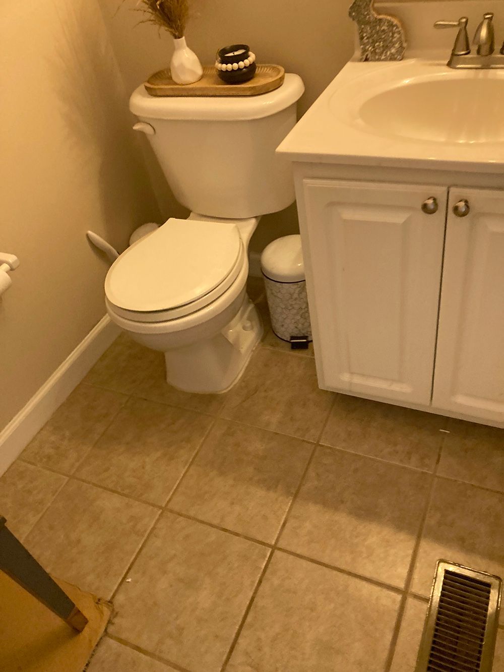 A bathroom with a toilet , sink and cabinets.