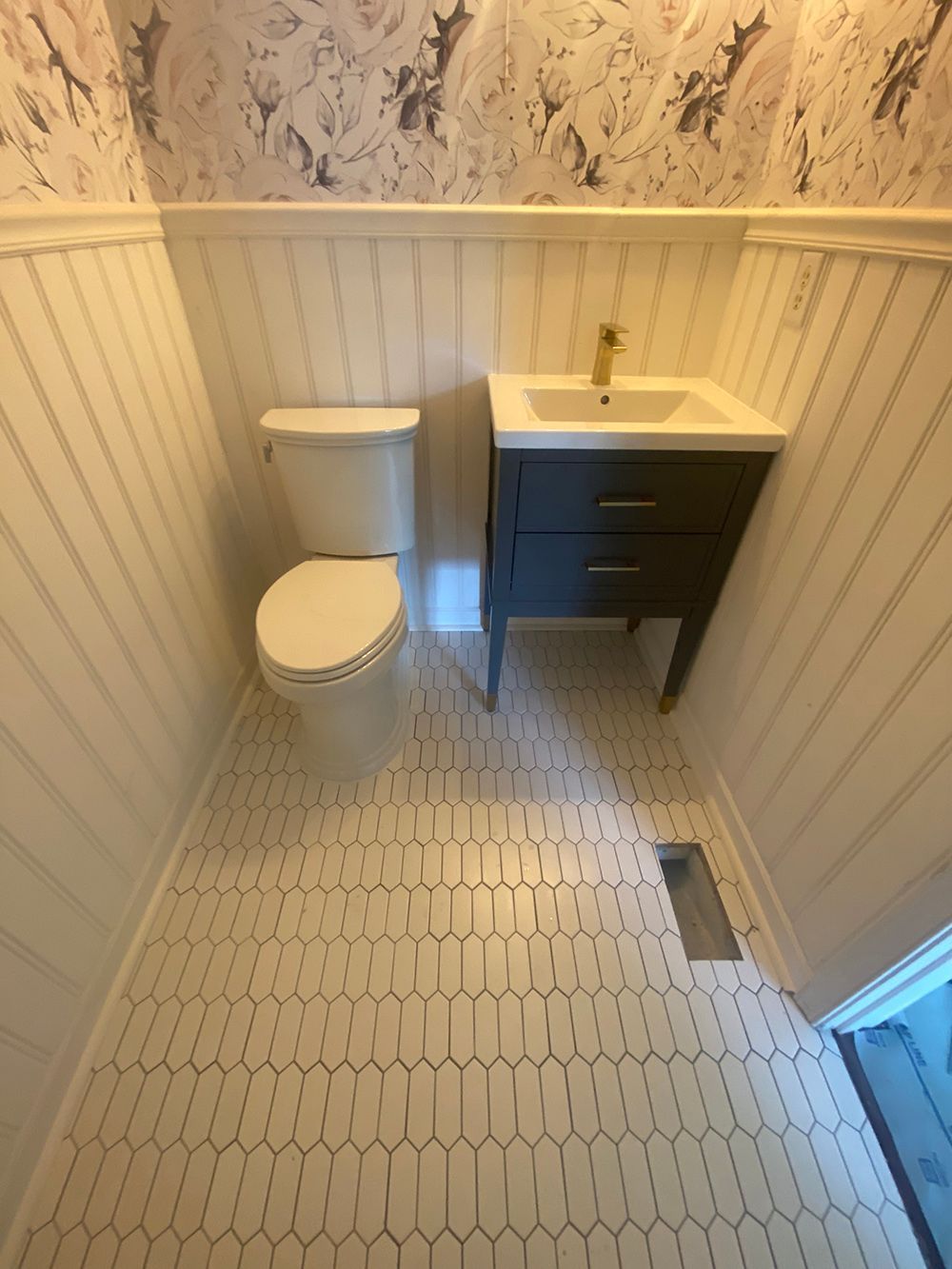 A bathroom with a toilet , sink and vanity.