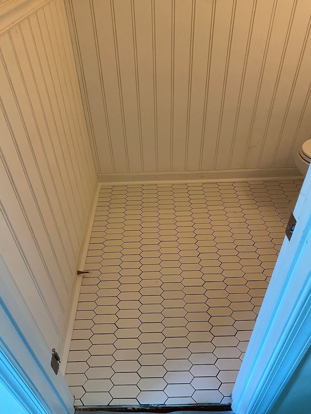 A bathroom with a tiled floor and a toilet.