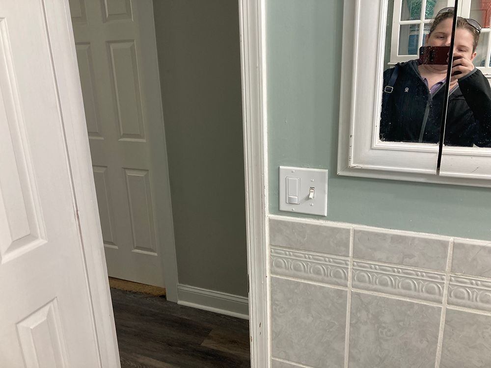 A woman is taking a picture of herself in a bathroom mirror.