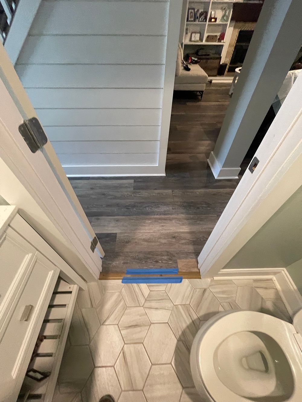 A toilet is sitting in a bathroom next to a door.