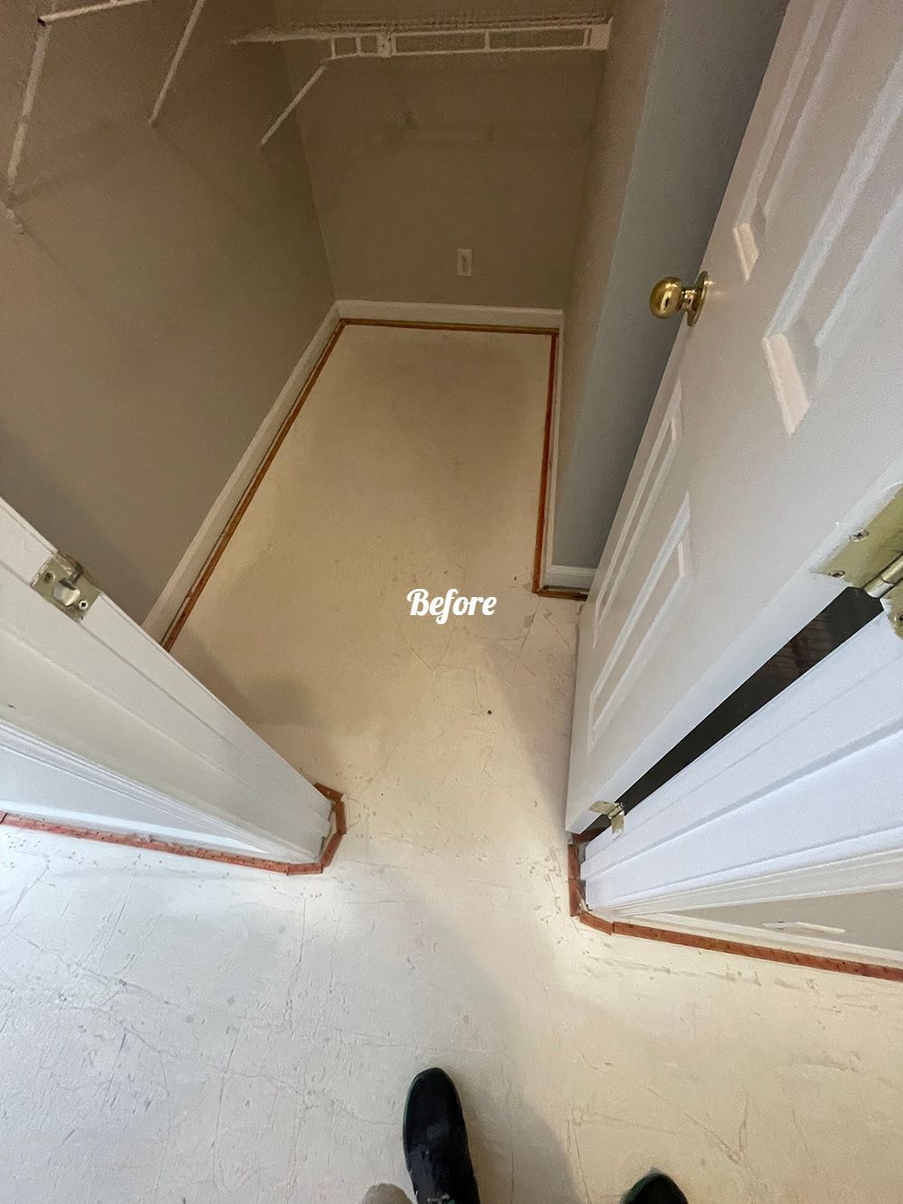 A person is standing in a closet with a carpeted floor.