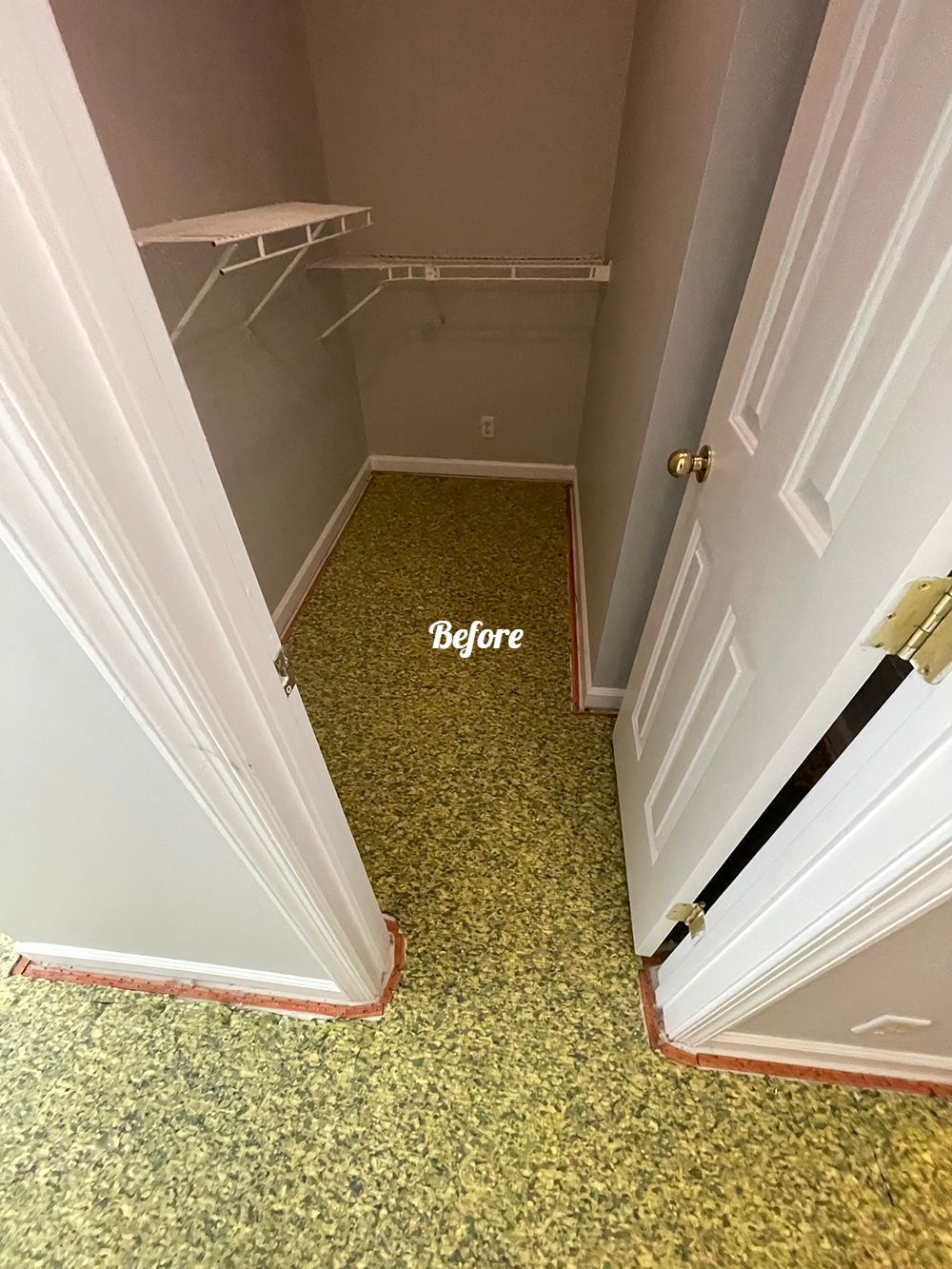 A closet with a yellow carpet and a white door.