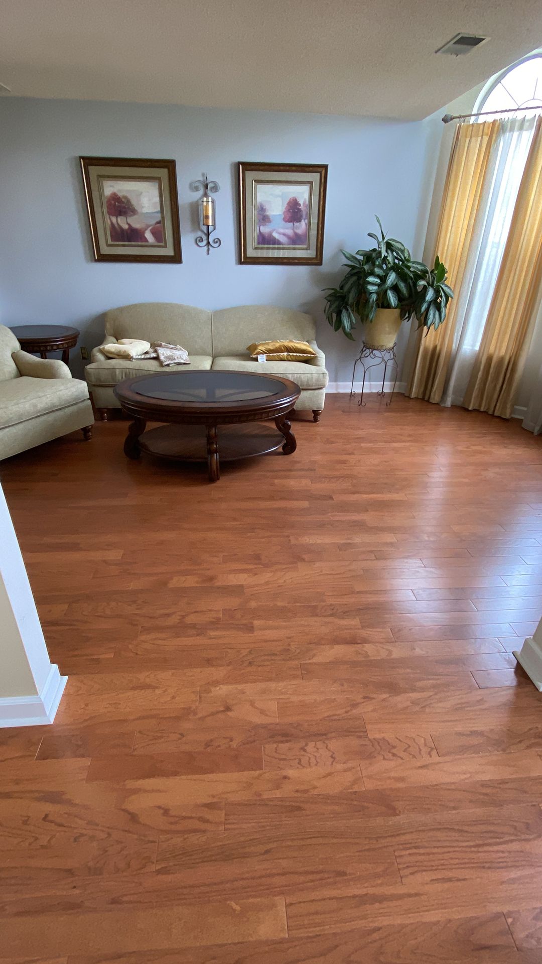 A living room with hardwood floors, a couch, chairs, and a coffee table.