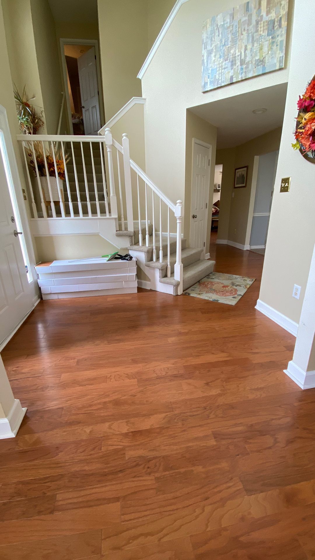 A hallway with hardwood floors and stairs in a house.