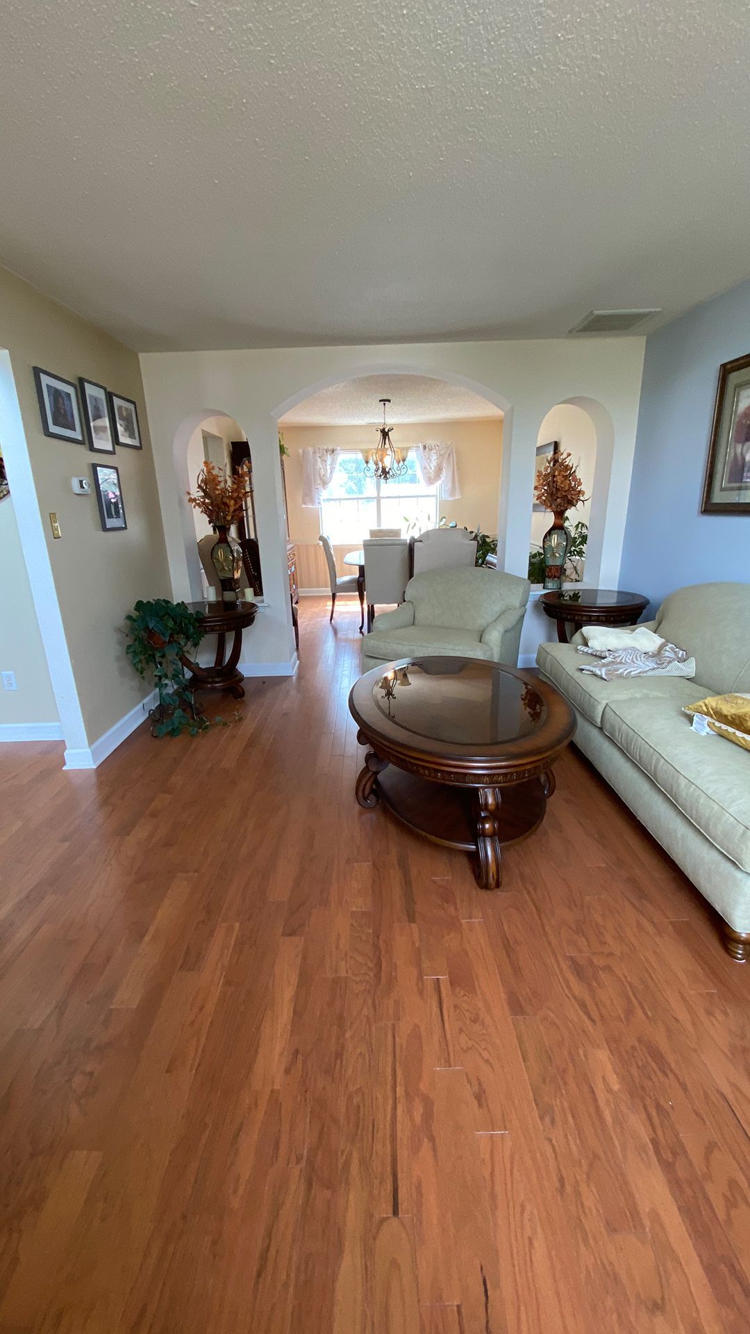 A living room with hardwood floors, a couch, chairs, and a coffee table.