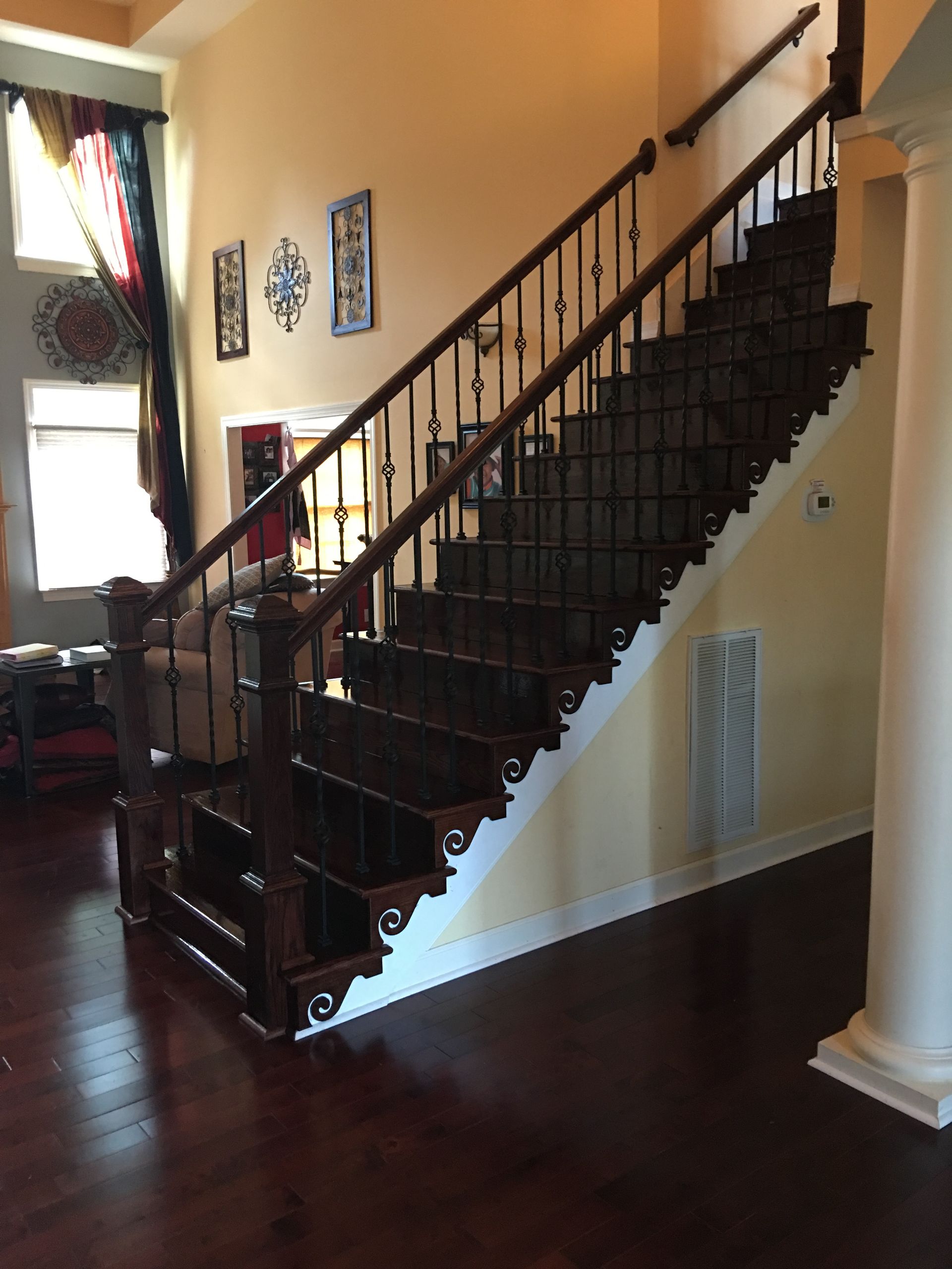 A wooden staircase with a metal railing in a living room