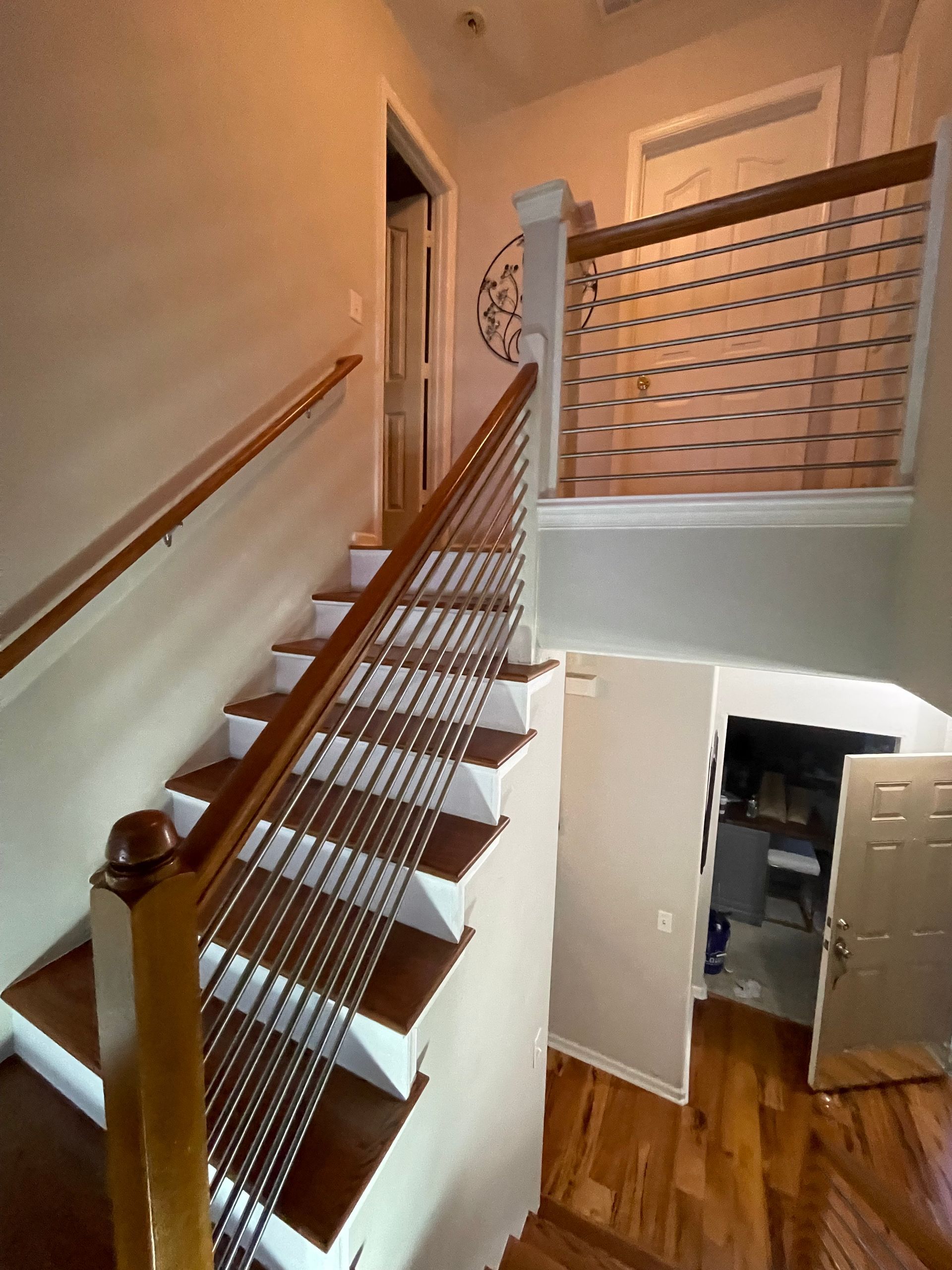 A staircase with a wooden railing and a metal railing