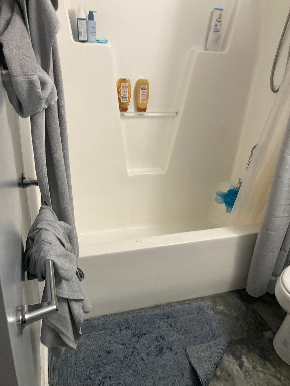 A bathroom with a tub, shower and toilet.