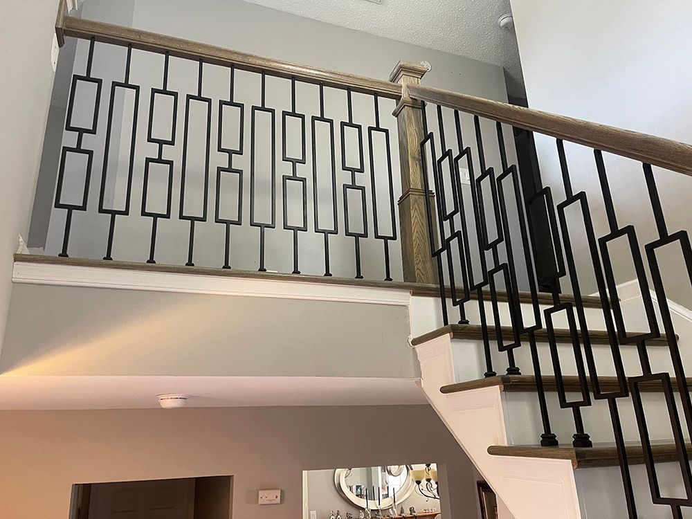 A staircase with a wooden railing and a metal railing in a house.