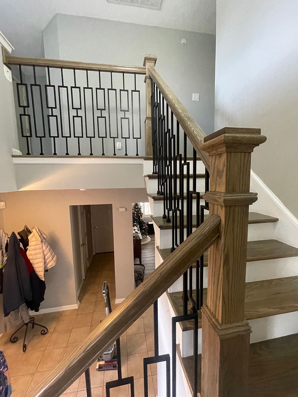 A wooden staircase with a metal railing in a house.
