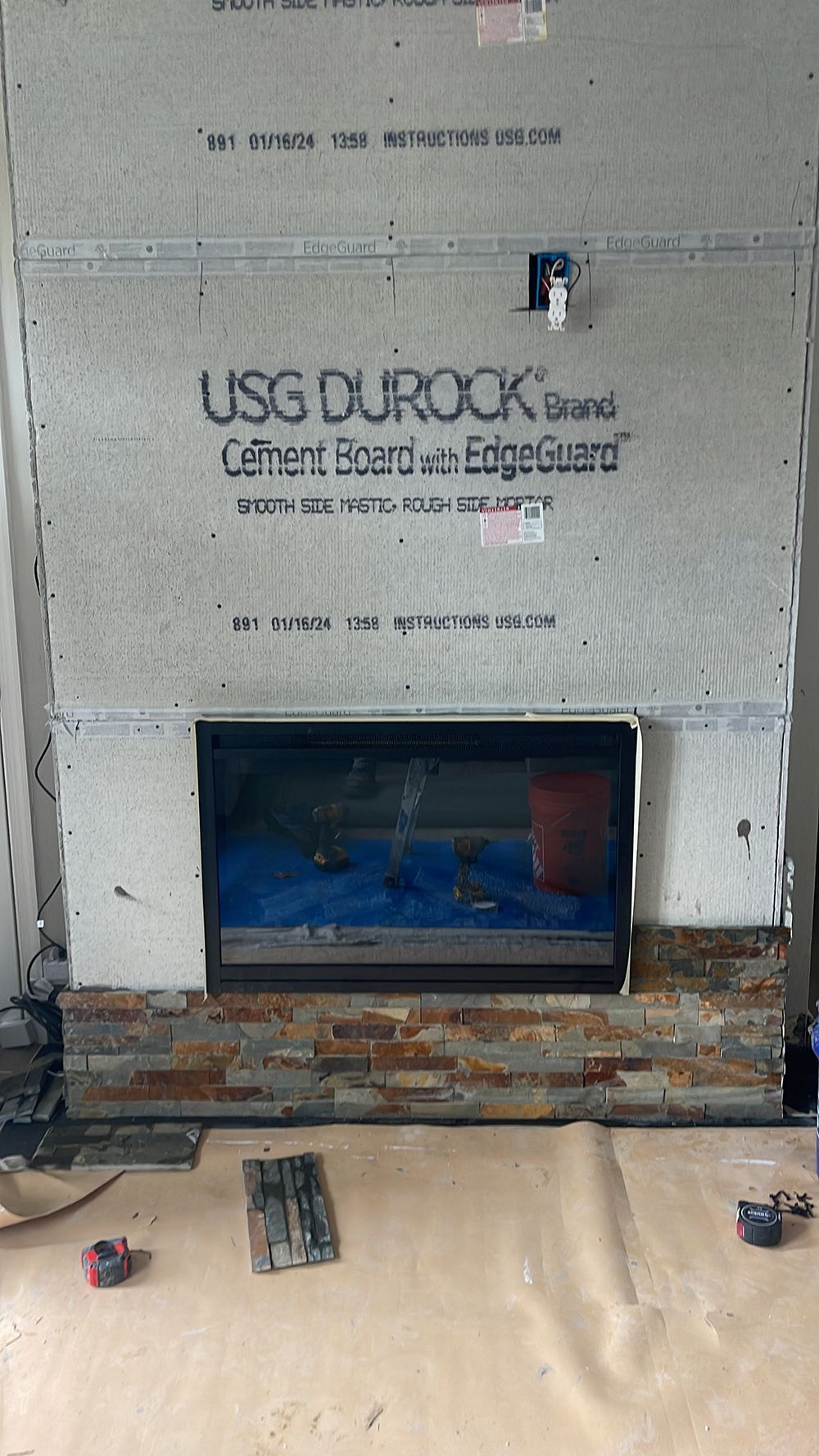 A fireplace is being built in a living room.