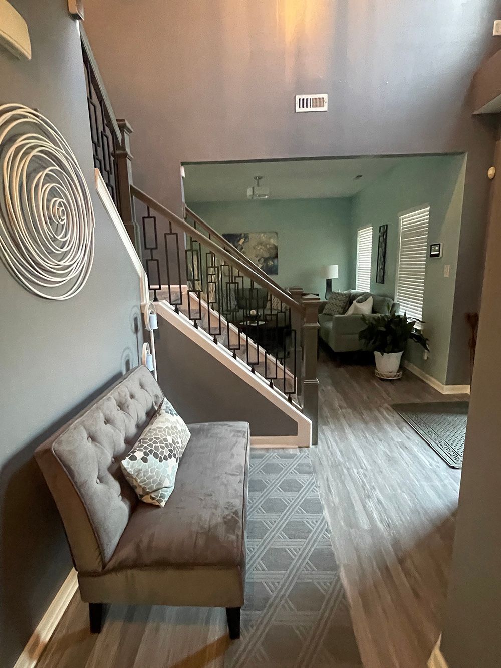A living room with a couch and stairs in the background.