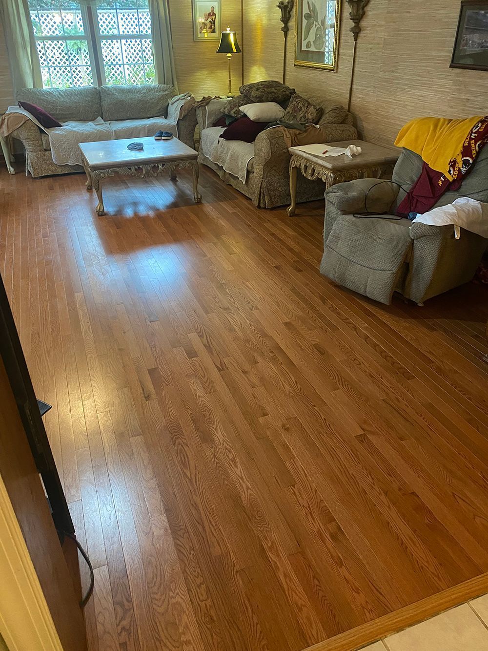 A living room with hardwood floors and furniture.