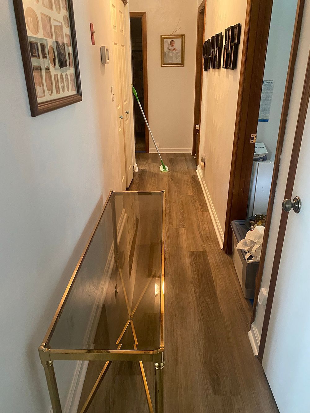 A long hallway with a glass table in the middle of it.