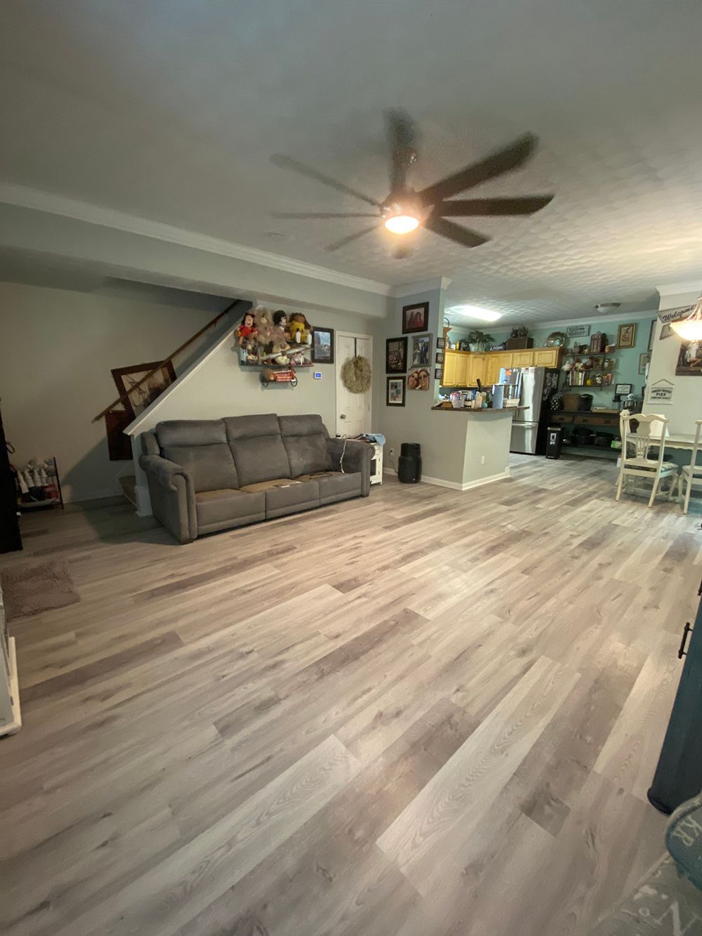 A living room with a couch and a ceiling fan.