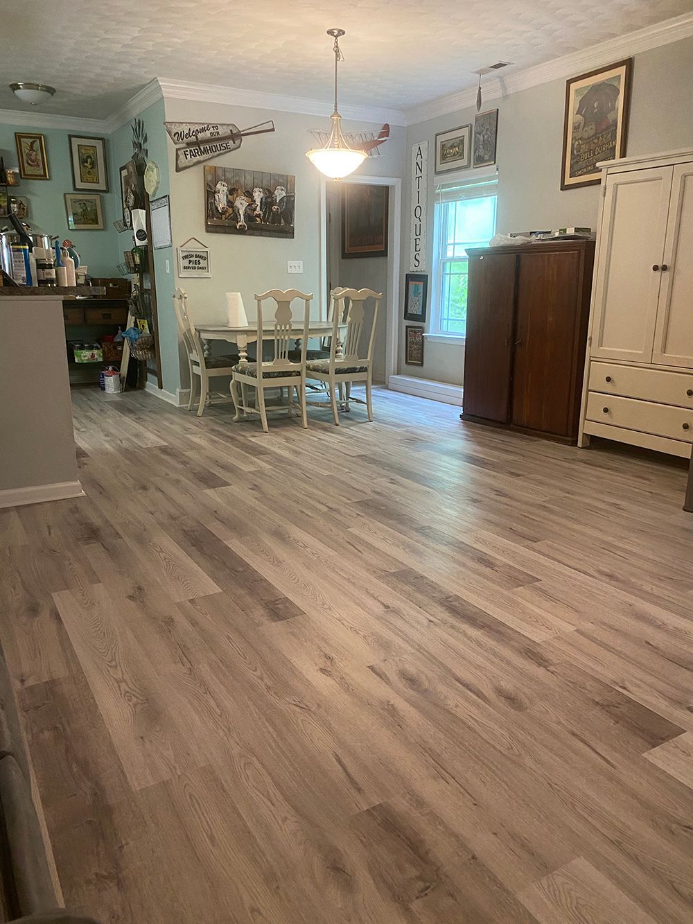 A living room with hardwood floors and a dining room table and chairs.