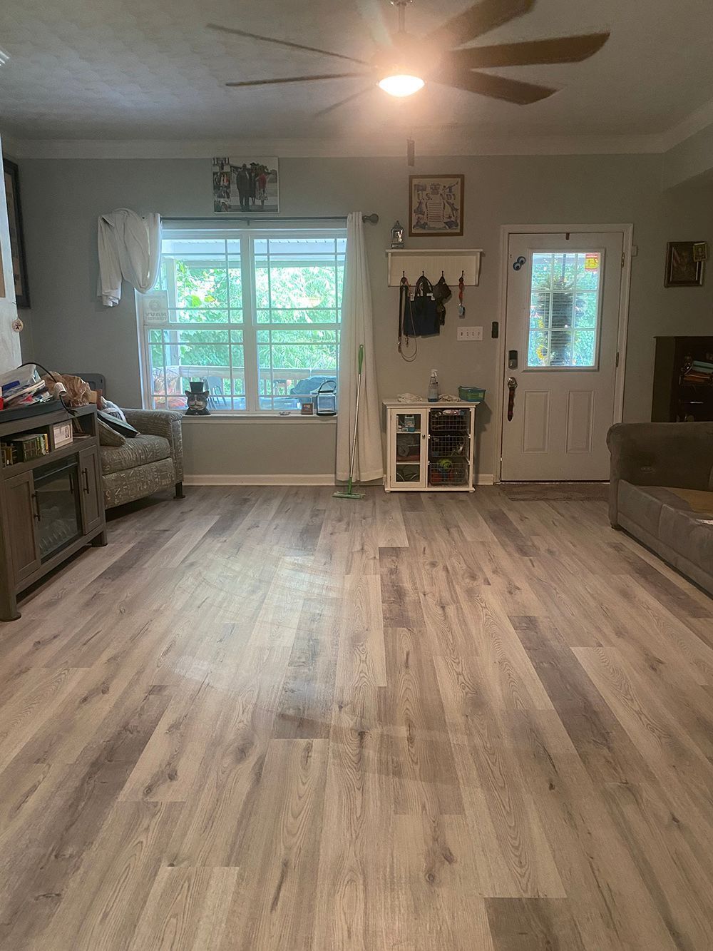 A living room with hardwood floors and a ceiling fan.