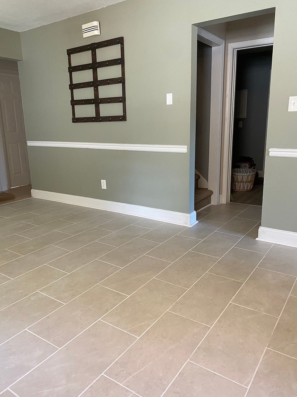 A living room with a tiled floor and a window on the wall.