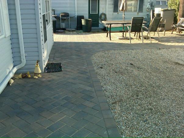A patio with a table and chairs in front of a house