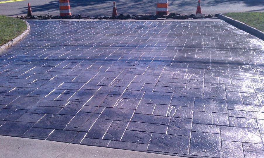 A brick driveway with cones on the side of it