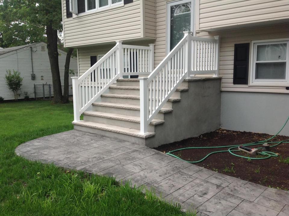 A house with stairs and a hose in front of it