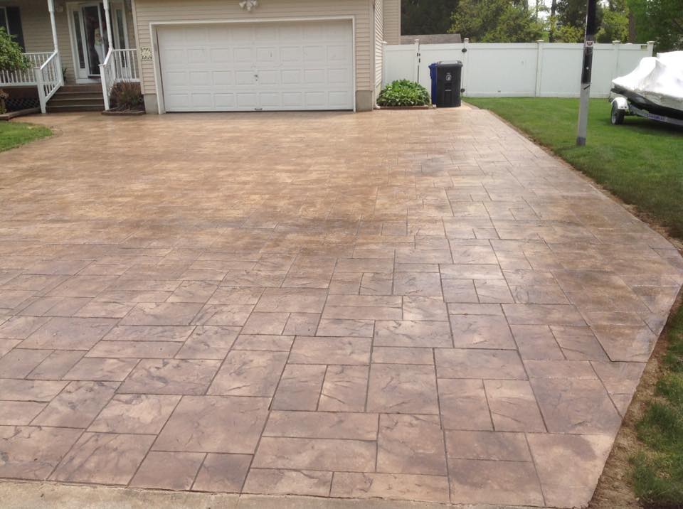 A car is parked in a driveway in front of a house.